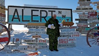 L'ambassadeur des Etats-Unis Jacobson devant le panneau indicateur de la nouvelle route pour Chicago à Alert, Nunavut