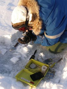 Une scientifique échantillonne le dépôt de neige en surface de la banquise arctique et détermine le type de cristaux
