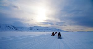 Motoneiges rentrant au coucher du soleil à Longyearbyen au Svalbard