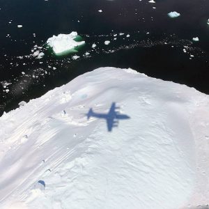 Ombre d'un avion de la mission IceBridge survolant un iceberg en 2017 dans le SE du Groenland